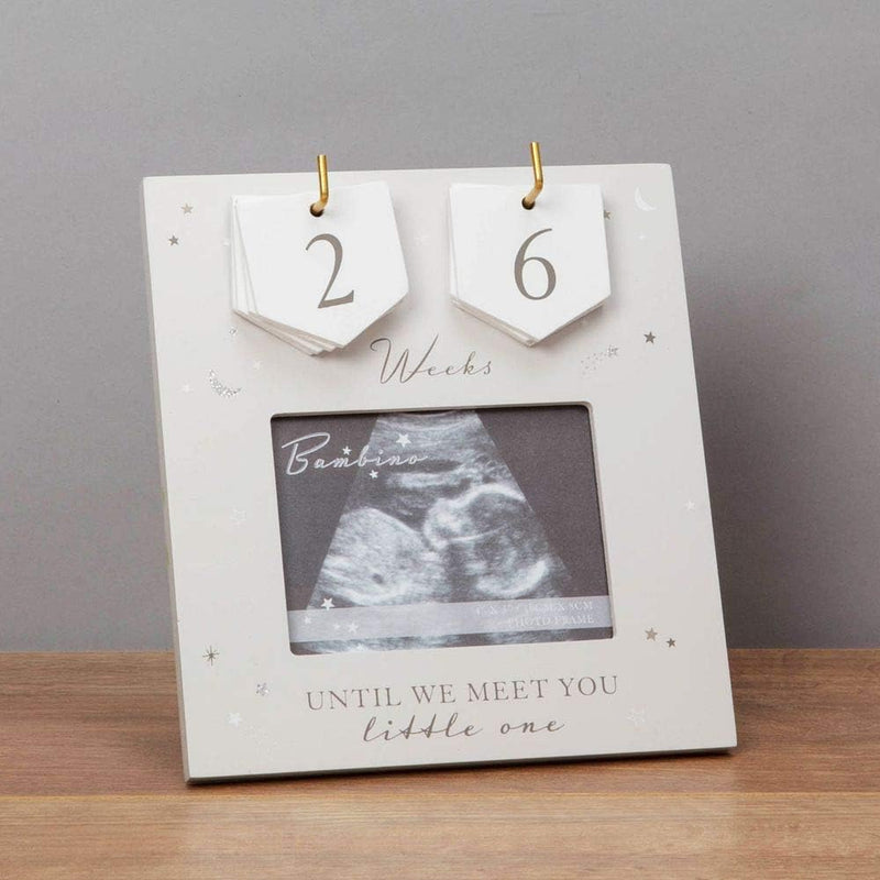 Baby countdown frame with ultrasound photo and 'Until we meet you, little one' text on a wooden surface.