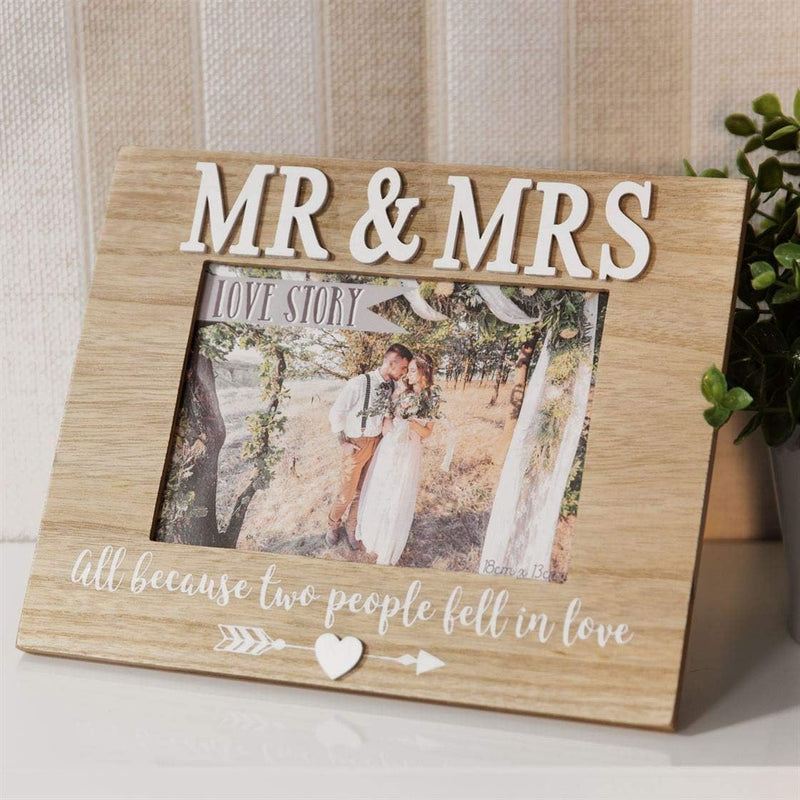 Wooden photo frame with 'MR & MRS' and a couple's picture inside, placed on a surface.